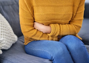 A woman with IBS symptoms holding her stomach