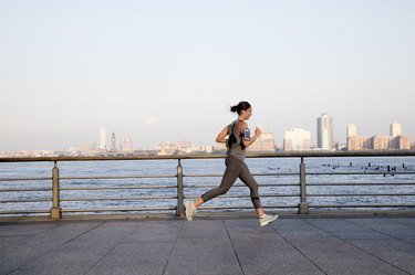 Young woman running along Hudson River