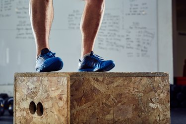 Closeup of athlete doing box jump at the gym