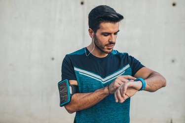 Jogger using a smart watch to measure heart rate while running