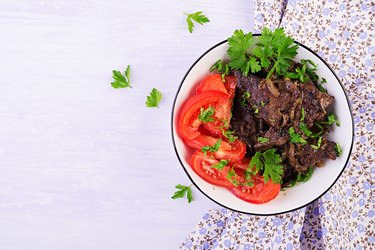 Roasted or grilled beef liver with onion and tomatoes salad. Middle Eastern cuisine. Top view