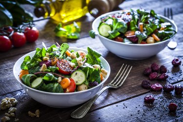 Two fresh salad bowls on a wooden table