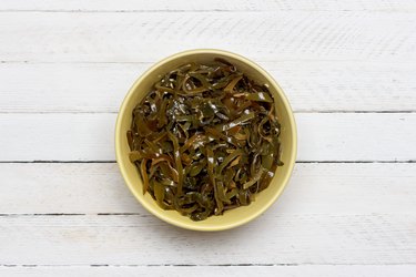 sea cabbage and sesame salad on white wooden background top view close-up