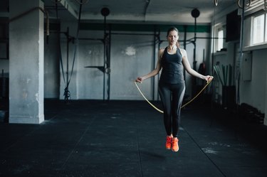 Attractive young woman uses jumping rope to train