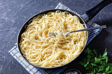 cacio e pepe, traditional Italian dish of pasta spaghetti mixed with grated pecorino cheese and dusted with freshly ground black pepper