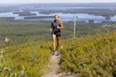 Woman running on track up hill