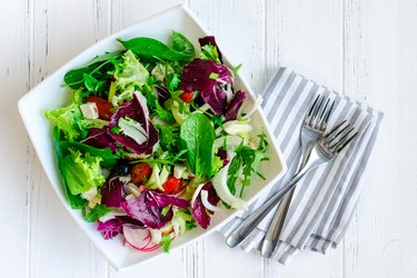 Fresh summer green salad mix on a wooden table