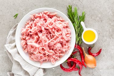 Mince. Ground turkey meat with ingredients for cooking on light grey background. Top view