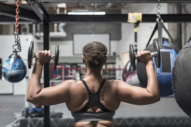 Person lifting dumbbells in gymnasium