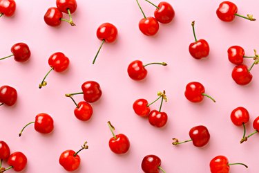 Tart cherry juice Flat lay of cherries on a pink background.Top view