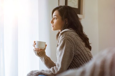 A woman at home drinking green tea or coffee for weight loss