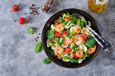 Healthy salad plate. Fresh seafood recipe. Grilled shrimps and fresh vegetable salad and egg. Grilled prawns. Healthy food. Flat lay. Top view