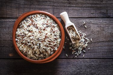Brown bowl filled with mixed rice shot from above on rustic wooden table
