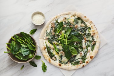 Pizza with chopped meat, spinach and cream sauce