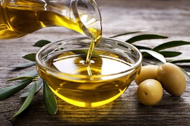 pouring olive oil into small glass bowl