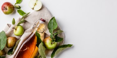 Close-Up Of Apple Cider Vinegar In Bottle Against White Background