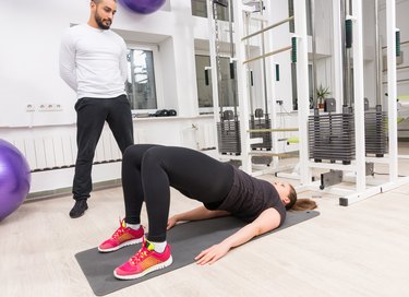 Woman raising hips during leg workout at gym