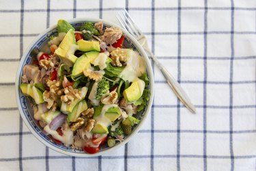 Tuna and avocado salad with walnuts on striped tablecloth for a keto diet