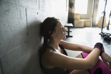 Tired woman resting at gym