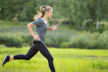 Woman listening to music and running in park