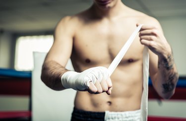 Fighter putting bendage on the hands before training