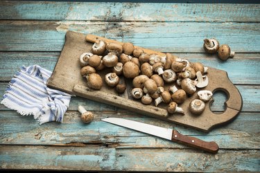 Crimini mushrooms on wooden chopping board