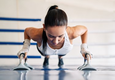 Young fit woman doing planks in gym