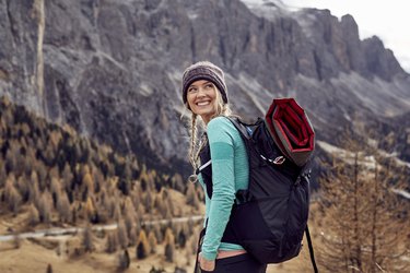 Portrait of happy young woman hiking in the mountains