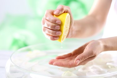 hands squeezing half of a lemon to use the fresh juice for skin care