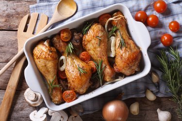 Baked chicken legs with vegetables in baking dish