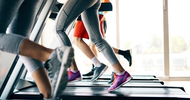 People running on treadmills in a gym