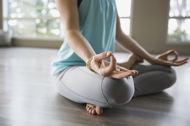 Woman in lotus position practicing mudra meditation