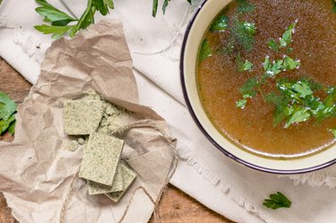 Bouillon cubes next to a bowl of broth