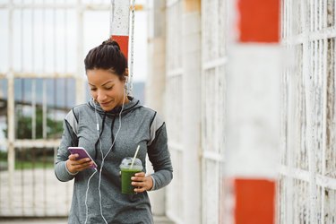 Urban fitness woman texting on her smarphone