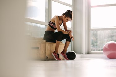 Woman checking fitness tracker during workout.