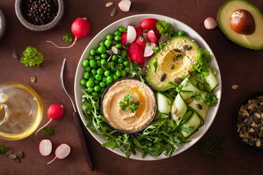 healthy vegan lunch bowl with avocado cucumber hummus peas radish