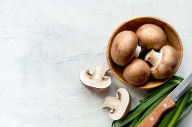 Sliced brown champignons on concrete background. Top view.