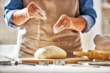 Hands preparing dough in kitchen for bread