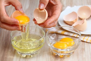 Woman hands breaking egg to separate  egg-white and  yolk