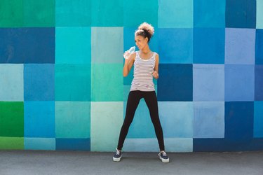 Woman runner is having break, drinking water