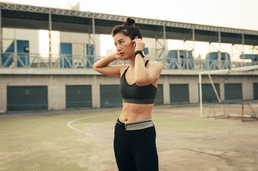 Portrait of a Runner: Fit Asian Woman With Wireless Earphones Ready to Run