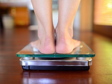 A view from the back of feet on a bathroom scale