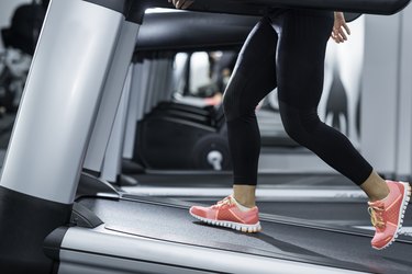 Close-up of person's legs walking on a treadmill to demonstrate how to burn 500 calories walking