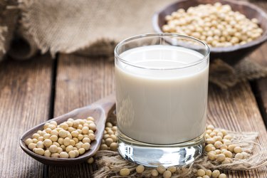 Soy beans on a wooden table with a glass of soy milk on the side