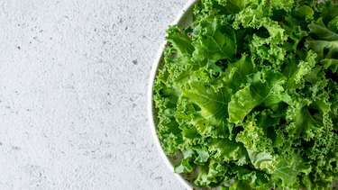 Kale leaves in bowl, copy space, top view