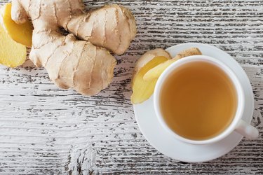 Ginger tea in a white cup on wooden background, as a natural remedy for sinus infections