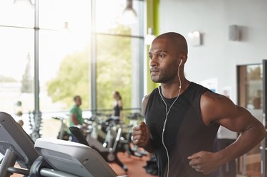 Man in a gym running on a treadmill.