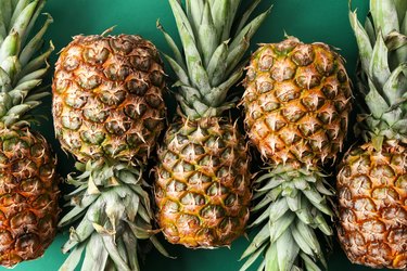 Ripe pineapples on color background