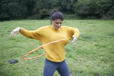 Woman hula hooping in field