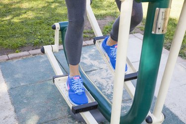 Cropped shot of womans legs training on step machine in park